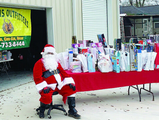 Santa sits amongst the huge number of soup and toys all waiting for the families to come by. Courtesy photo