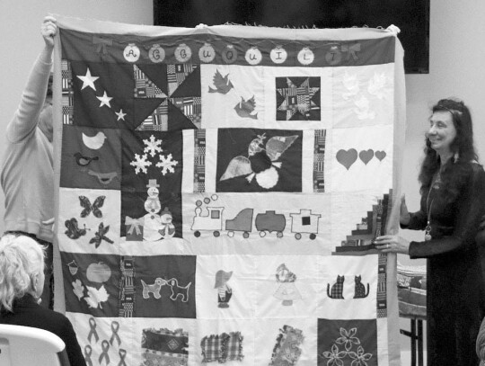 Diane Rose showing a pieced quilt.