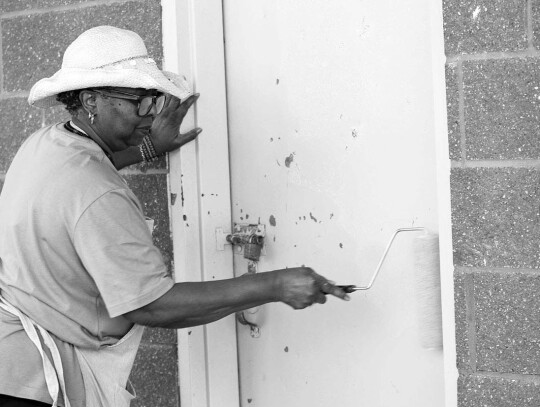 Willie Mae Williams painting the doors on the Thomas B. Hancher MD Pavilion.