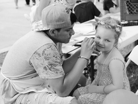 A young festival-goer gets her face painted at a past festival.