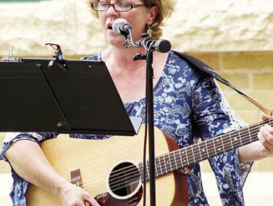 Tracy Baker leading the community in song at prayer gathering.