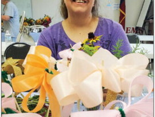 Brenda Boehm fixing bows for flower arrangements.