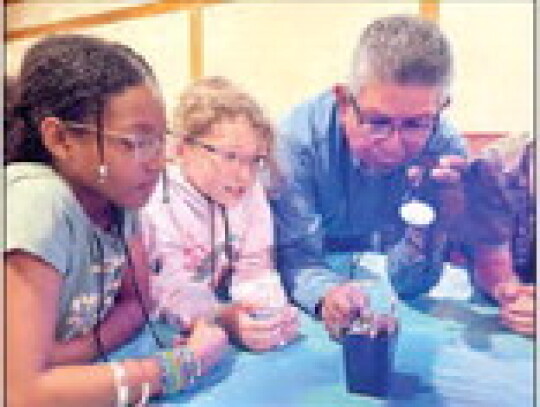 Keyleigh Crayton, Alexis Fisher and Joe Jiminez with Venus Flytrap under ultraviolet light. Courtesy | Cathy Dannemiller