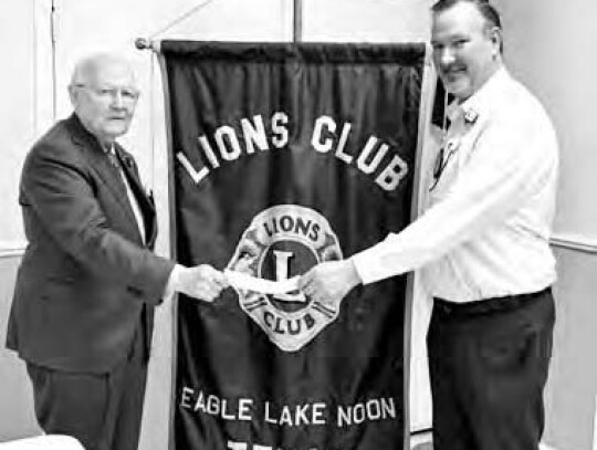 Eagle Lake Noon Lions Club President Stan Warfield presents Kurt Sunderman, assistant chief of the Eagle Lake Volunteer Fire Department a donation to be added to the brush truck fund.