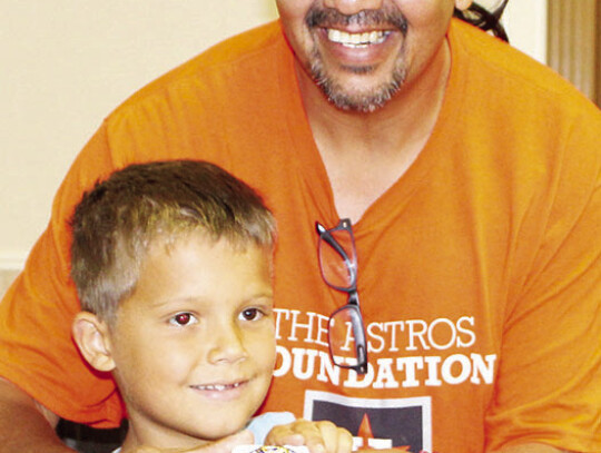 Astros Foundation volunteer John Morales and Lane Kolafa who won the World Series Championship replica ring.