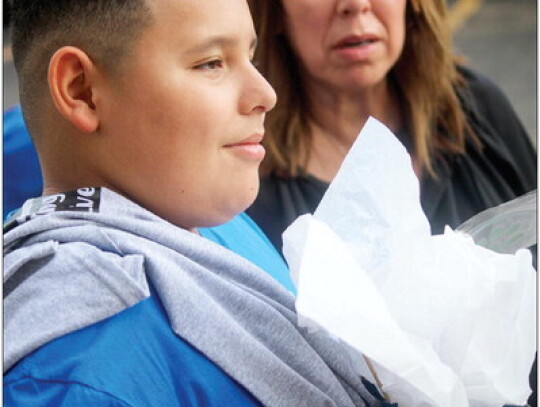 Paul Picasso receives a goodie bag as a thank-you from Columbus Rescue Dogs with his mother Terry Picasso behind him.