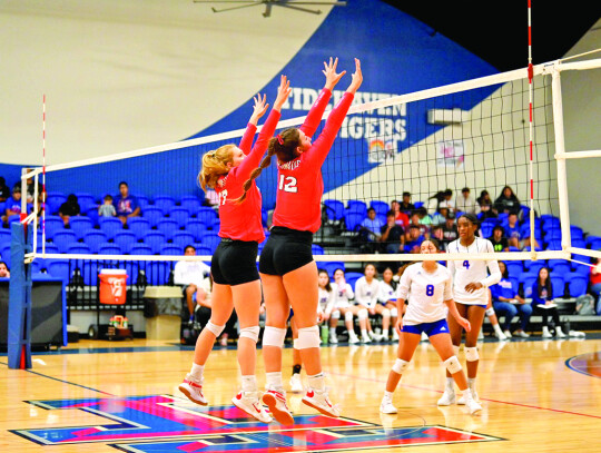 Klausmeyer and Schobel- Claire Klausmeyer and Gracie Schobel going up for a block at the net.