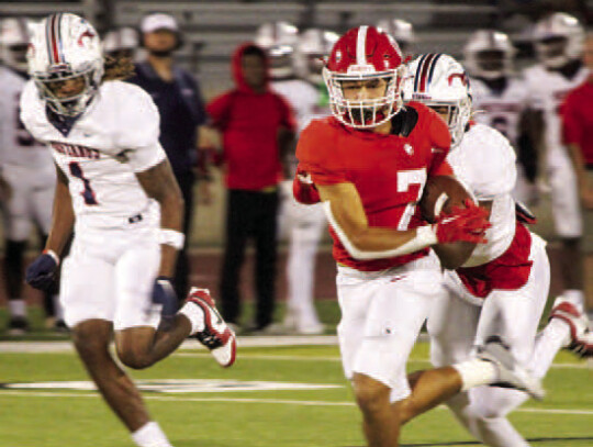 Cardinals’ senior receiver Jackson Hancock breaks a tackle to carry the ball deep into Mustang territory before being tackled.