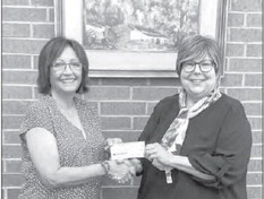 Ester Chandler presents Nesbitt Memorial Librarian Susan Chandler with a check donation.