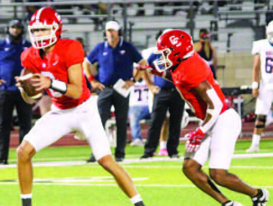 Junior quarterback Adam Schobel takes the snap and hands off the senior running back Ty’Vone Whitehead for a big gain.