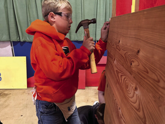 SAS 5th grader Jace Tribe helps build a small house at Blinn College’s “If I Had a Hammer” program.