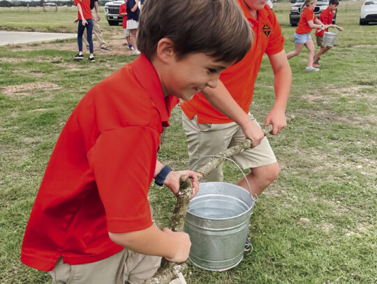 SAS 4th graders Clark Smith and Jase Brownlow try their hand at an old-time relay race while visiting the Zimmerscheidt School