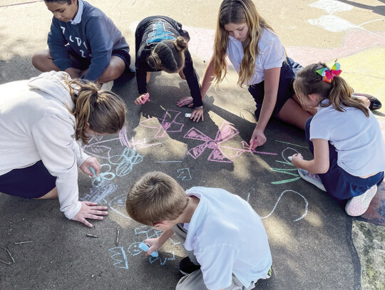 Older students paired with younger grades for fun and games after the picnic meal.