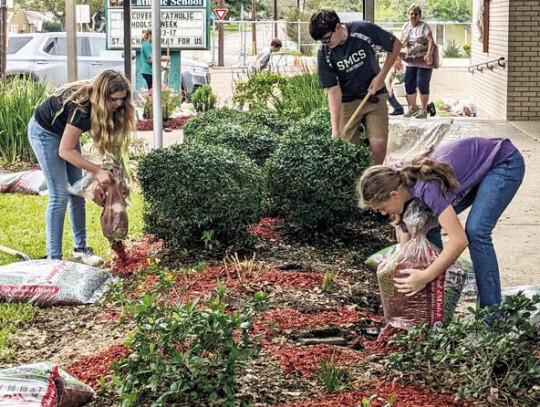 St. Michael Sixth Graders spruce up the school’s flowerbeds as a service project during Discover Catholic Schools Week.