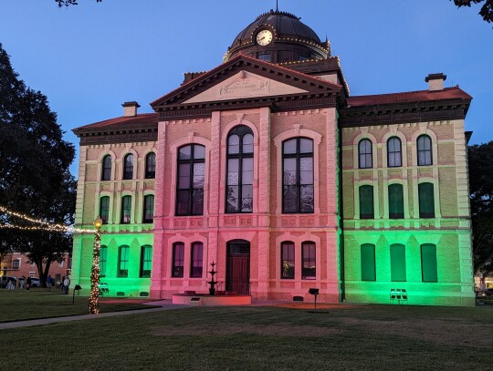 The Colorado County Courthouse displayed green and red lights as part of the courtyard decorations.