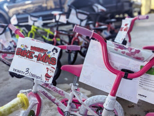 Left: Za’Dayha Carter takes a picture with the Grinch after receiving her bike. Right: Lil Einstein’s had a few dozen bikes available for their students, several of which were equipped with training wheels.