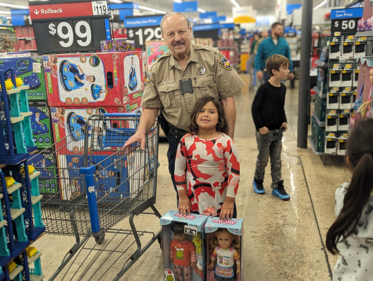 Officer Donnie Templeton helps a child pick her gifts for Christmas. Citizen | Trenton Whiting