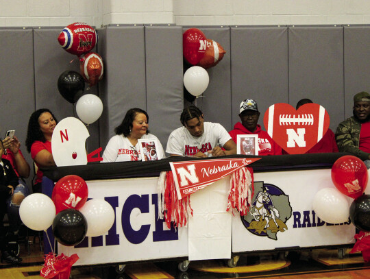 Roger Grandey (middle) committed and signed to continue his athletic and academic career at the University of Nebraska.