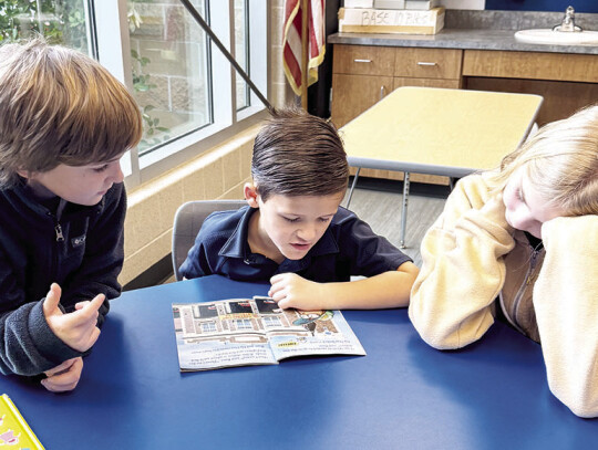 1st grader Gunnar Radley shows off his reading skills to 4th graders Clark Smith and Khloe Warschak during a confidence building exercise.