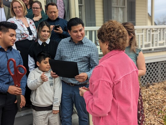 Janet Hollman presents a plaque welcoming Lamberto’s restaurant into the city.