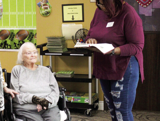Brenda Hull (right) reading a piece of scripture to Julia Austin (seated) to kick off her birthday celebration. Citizen | Evan Hale
