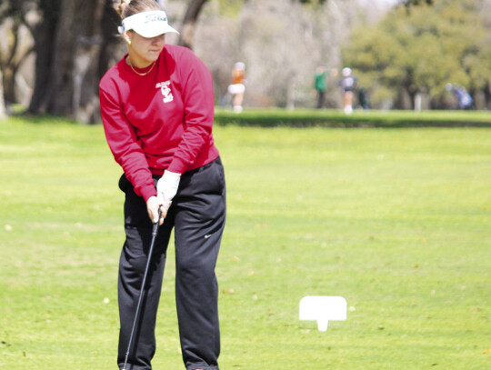 Kerigan Faldyn watching as her putt falls into the hole.