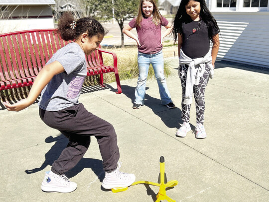 Sophia prepares to launch while Emesyn Ellis and Jasmine Cordova watch from a safe distance.