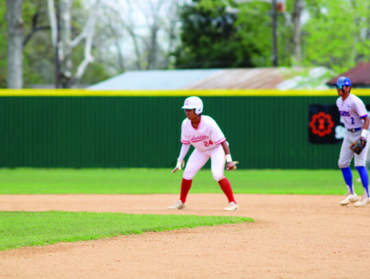 Trinity Thompson taking a lead from second base before stealing third on a wild pitch.