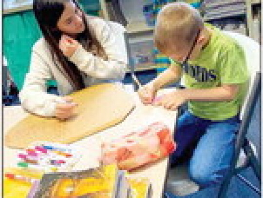 8th grader Ella Herzik helping Kindergartener Steven Herzik.