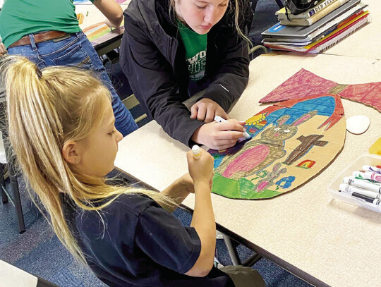 With the help of 7th and 8th graders, Pre-K and Kindergarten students made traditional Swedish Easter trees called Påskris. Pictured are Chloe Brandt with Kindergartner Kennedy Vanicek.